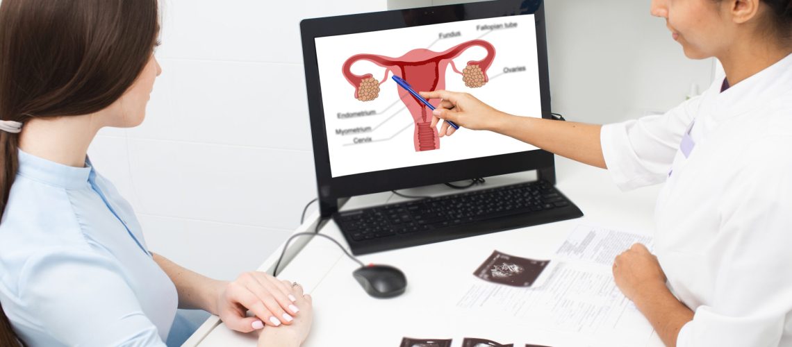 gynecology, consultation. Gynecologist explains a woman with diseases of the uterus and ovaries, pointing on atomic uterus